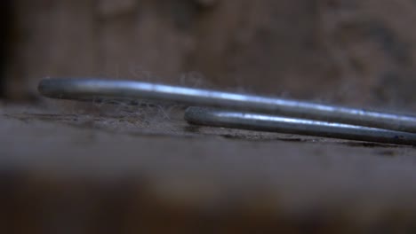 An-extreme-close-up-panning-shot-of-a-paperclip-that-sits-on-a-ledge