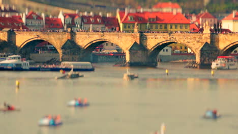 Charles-bridge-view-from-vltava-river-with-ships,-tourists,-boats-in-a-sunny-day