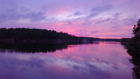 Slow-pan-of-a-lake,-at-purple-sky,-colorful-sunset-or-dusk,-at-Albysjon,-Tyreso,-Sweden