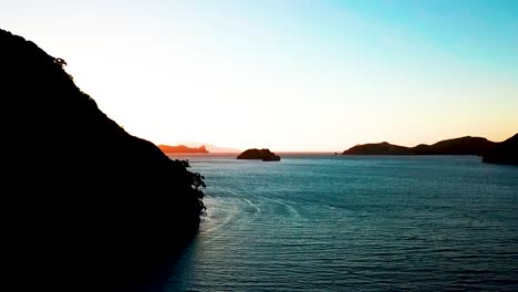 Ein-Langsamer-Schwenk-über-Das-Meer-Zeigt-Einen-Wunderschönen-Sonnenuntergang-über-Den-Gipfeln-Der-Neuseeländischen-Inseln
