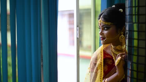 Romantische-Und-Nachdenkliche-Indische-Braut,-Die-Abends-Aus-Dem-Fenster-Schaut