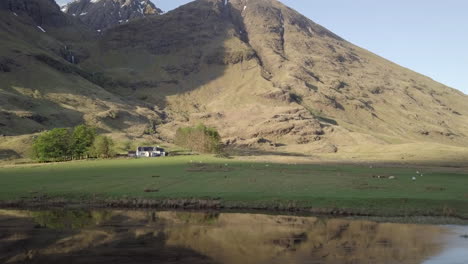 An-Einem-Sonnigen-Tag-über-Den-Loch-Achtriochtan-In-Richtung-Eines-Highland-Cottages-Fliegen,-Glencoe,-Schottisches-Hochland,-Schottland