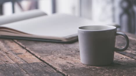 Heiße,-Dampfende-Kaffee-Tee-Tasse-Mit-Buch-Auf-Dem-Holztisch-Zum-Lernen-Und-Entspannen