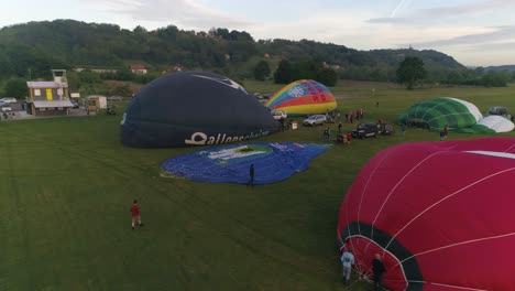 Aerial-orbit-shot-panning-around-balloons-and-teams-prepare-for-show