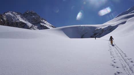 Backcountry-skiers-ascending-towards-glacial-ice-cave