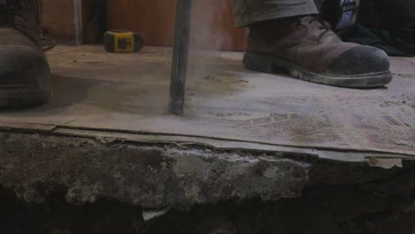 Close-up-on-concrete-demolition-drill-bit-and-worker-boots-with-smoke-rising-from-drill-head
