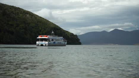 Pelorus-Mail-Boat-in-Marlborough-Sounds,-New-Zealand-with-green-hills-in-background