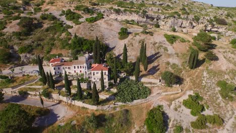 Aerial:-A-monastery-and-caves-in-the-mountains-of-Samos,-Greece