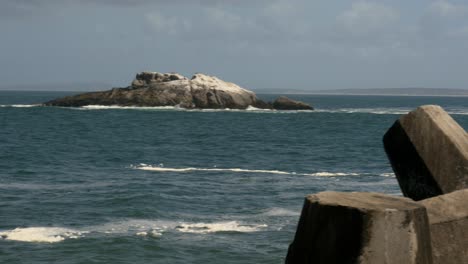 The-cold-Atlantic-from-a-breakwater-with-an-island-coming-into-view-PANNING