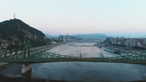 Aerial-view-of-Tram-passing-through-Liberty-bridge-on-river-Danube-in-Budapest-in-the-morning