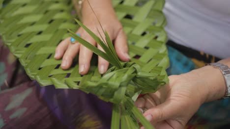 Closeup-of-a-woman-weaving-a-plant-in-a-traditional-maori-way-in-new-zealand
