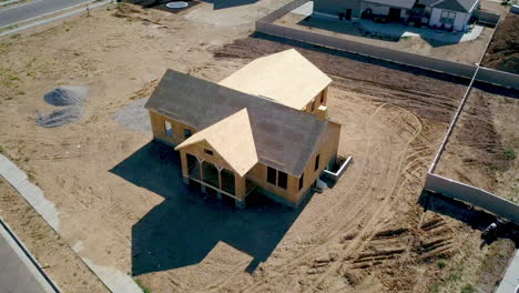 Ein-Drohnenschuss,-Der-Um-Ein-Neu-Gebautes-Haus-Schwebt,-Dessen-Wände-Und-Dach-Kaum-Platziert-Sind