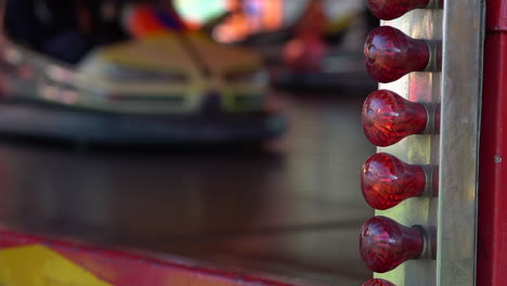 Close-up-of-Blinking-Red-Lights-while-people-are-having-fun-driving-Bumper-Cars-at-the-Fun-Fair