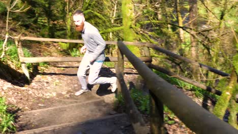 SLOW-MOTION-of-man-running-up-a-forest-carved-slope