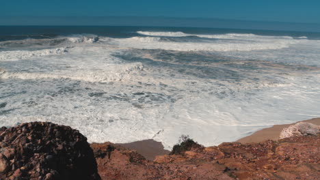 Wildes-Wasser-Von-Großen-Wellen,-Die-An-Einem-Sonnigen-Tag-Am-Praia-Do-Norte-In-Nazaré-Krachen
