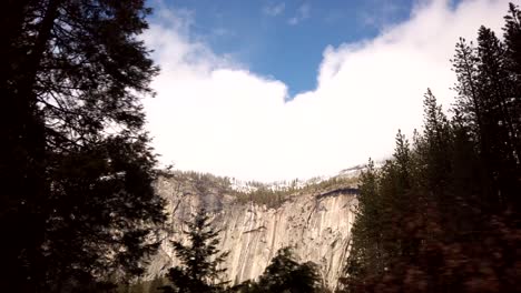 Eine-Pause-In-Den-Dichten-Kiefernwäldern-Des-Yosemite-Nationalparks-Offenbart-In-Der-Ferne-Einen-Hellen,-Von-Bäumen-Gesäumten,-Schneebedeckten-Berg-Aus-Granit