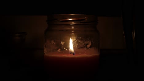 A-Wide-Shot-of-a-Moving-Candle-Light-In-A-Dark-Silent-Room-In-The-Night