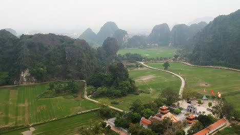 Aerial-view-of-Vietnamese-countryside,-Limestone-rocks-and-Thai-Vi-Temple-in-Tam-Coc,-Ninh-Binh,-Vietnam