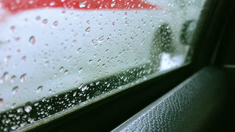 In-Einem-Fahrenden-Auto,-Dessen-Fenster-Mit-Wassertropfen-Bedeckt-Ist,-Fokussieren-Sie-Sich-Bei-Starkem-Regen