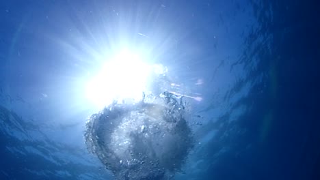 the-sun-seen-from-below-water-with-bubbles-coming-up-towrds-the-sun