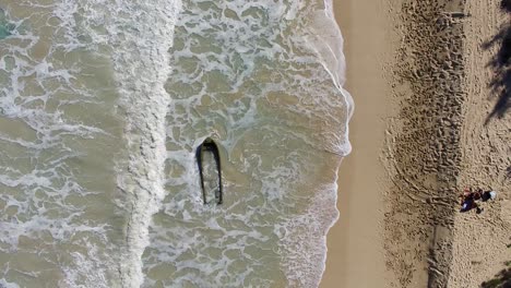 Aerial-shot-of-partially-sunken-boat-at-Bellows-Field-Beach-Park