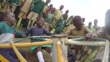 Afrikanische-Kinder-Drehen-Sich-Auf-Einem-Spielplatzkreisel-Herum,-GoPro-Aufnahme