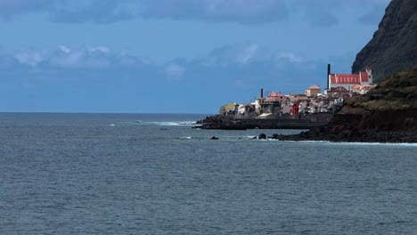 Scenic-veiw-of-the-Picturesque-fishing-village-of-Paul-do-Mar-in-Madeira-Island-in-the-Atlantic-Ocean-blue-sky-with-clouds-calm-peaceful-sea