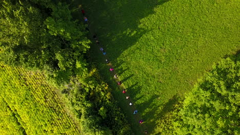 Aerial-view-of-a-group-of-people-walking-in-a-line-on-a-grassy-prairie