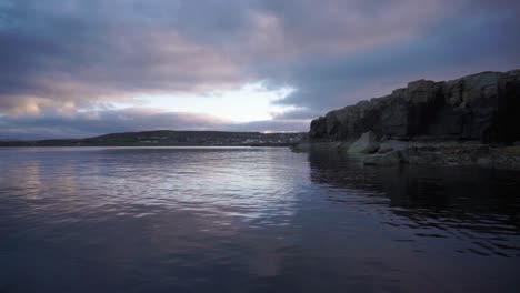 Blauer-Sonnenuntergang-über-Der-Bucht-Mit-Felsigen-Klippen-Und-Wolken