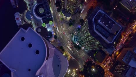 Aerial-hyperlapse-timelapse-of-modern,-busy-city-street-intersection-and-tall-buildings-at-night