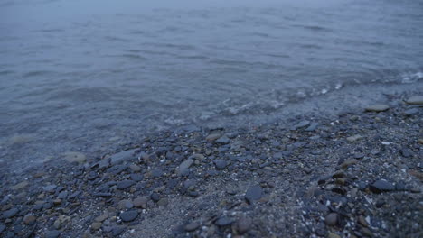 Cool-colored-waves-rolling-onto-a-gravel-shore