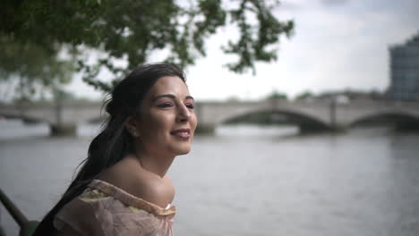 Close-Up-of-an-attractive-latina-tourist-looking-at-river-Thames-in-London,-slow-motion-shot