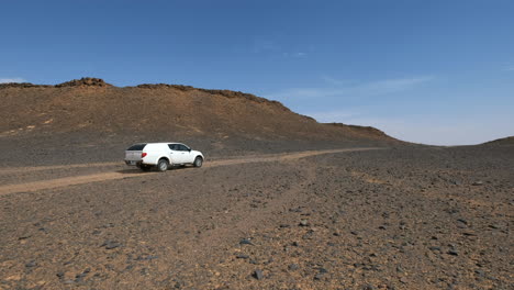Pickup-truck-driving-by-in-a-hot-Sahara-desert-in-Morocco