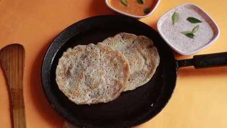 Rotierendes-Oothappam---Dosa---Südindisches-Frühstück-Mit-Reis,-Linsen-Und-Gemüse,-Serviert-Mit-Kokosnuss-Chutney,-Isoliert-Auf-Gelbem-Hintergrund