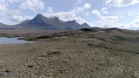 Aerial-tracking-fast-along-the-moorland-ground-looking-on-towards-the-magnificent-mountain-of-Ben-Loyal
