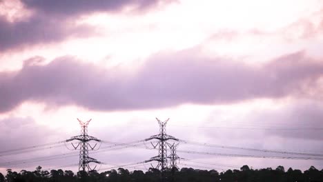 Storm-clouds-passing-by-electricity-pylons-in-complete-silhouette