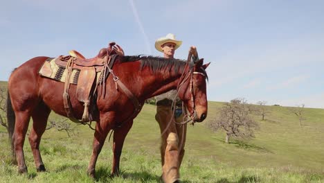 With-a-con-trail-overhead,-the-cowboy-gets-off-his-horse
