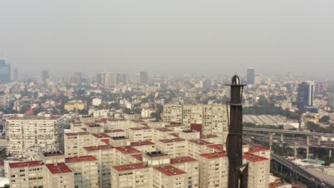Aerial-shot-of-a-big-monument-in-a-very-polluted-day-in-Mexico-City