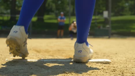 Woman's-Fast-Pitch-Softball,-Low-Angle-Pitcher's-Mound-With-Cleats,-Blurred-Catcher-Background,-High-School-Coaching,-Throwing-A-Curve-Ball,-College-Recruiting