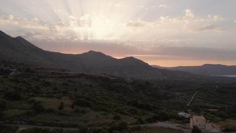 Luftaufnahme-Einer-Landschaft-Und-Berge-Auf-Kreta,-Griechenland-Bei-Sonnenuntergang-Mit-Sonneneruptionen-Und-Warmen-Farben