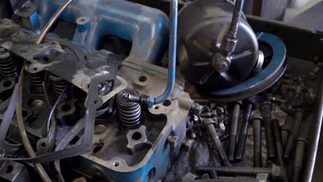 Workbench-with-close-up-of-engine-cylinder-head-and-miscellaneous-auto-parts