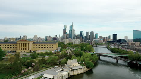 Drone-Aerial-rising-above-Philadelphia-city-skyline-showing-Comcast-Technology-Center,-Art-Museum,-and-Schuylkill-river