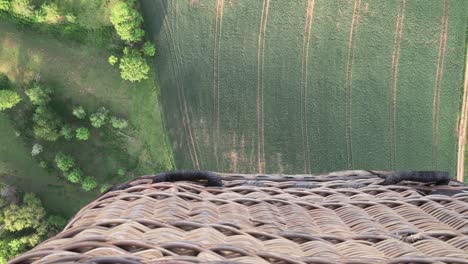 Flying-over-fields-and-trees-in-hot-air-balloon,-down-view-with-a-basket,-great-cinematic-shot-with-feeling-of-the-moment-in-the-air