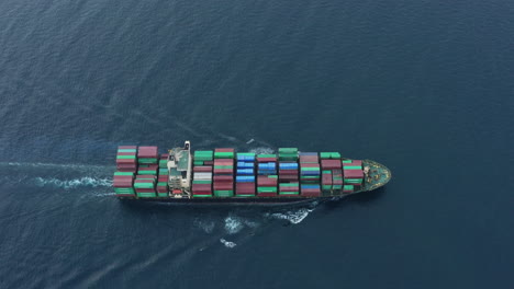 Logistics-cargo-ship-transports-freight-containers---motoring-in-ocean-as-seen-from-drone