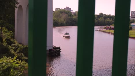 Der-Cuyahoga-River-An-Einem-Klaren-Tag-Mit-Einem-Boot,-Das-Durch-Ein-Geländer-Vorbeifährt