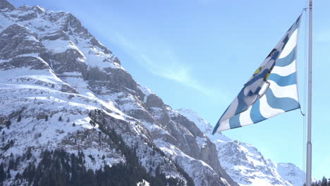 Schweizer-Kanton-Bünden-Flagge-Weht-Im-Hintergrund-Schneebedeckte-Berge-4k-videomaterial