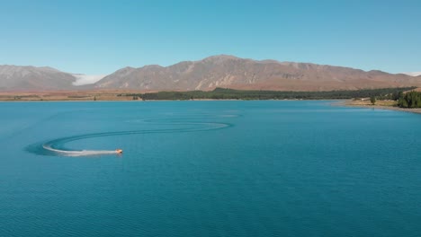 FASTMO---Jet-Ski-on-Beautiful-Turquoise-Blue-Water---Lake-Tekapo,-New-Zealand---Aerial