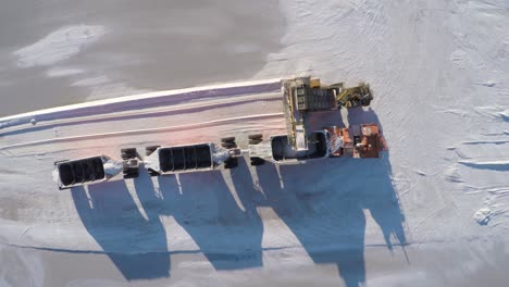 Aerial-cenital-plane-shot-of-a-large-truck-being-filled-with-salt-in-the-salt-flats-by-solar-evaporation-in-Guerrero-Negro,-Ojo-de-Liebre-lagoon,-Biosphere-Reserve-of-El-Vizcaino,-Baja-California-Sur