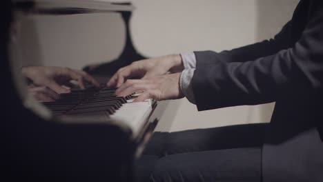 Pianista-Masculino-Interpretando-Una-Canción-En-El-Piano-Con-Poca-Luz-Y-Poca-Profundidad-De-Campo-Con-Movimiento-Deslizante