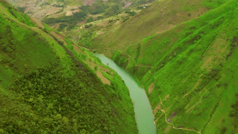 Aerial-shot-over-the-gorgeous-turquoise-blue-green-water-of-the-Nho-Que-river-in-northern-Vietnam